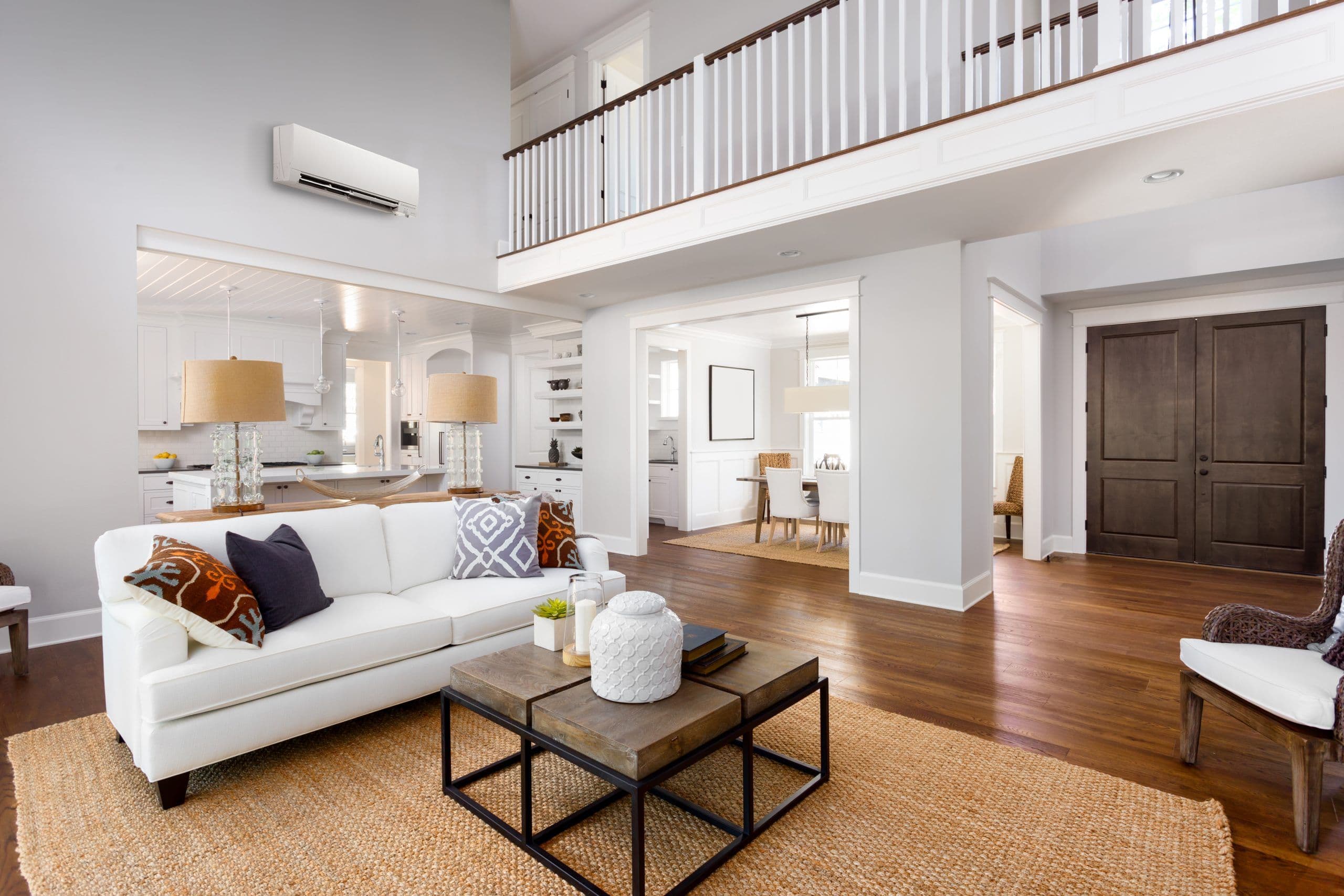 Bright living room with a wall-mounted ductless heat pump above the sofa