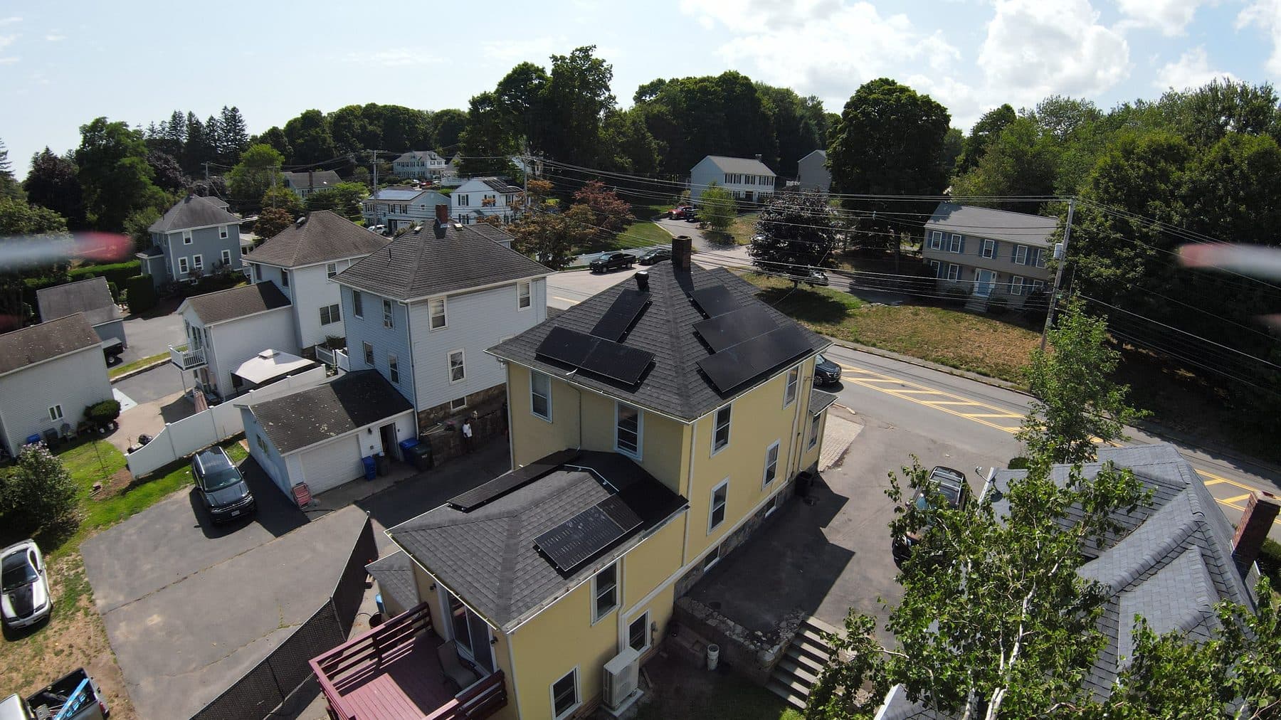 Aerial view of a Massachusetts home with solar panels installed by Lela Homelife